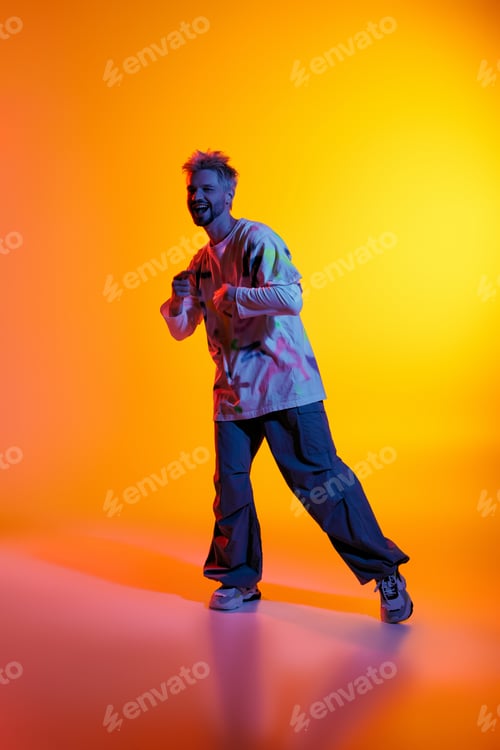 Preview: Dynamic expression of joy by a handsome young man in vibrant studio setting