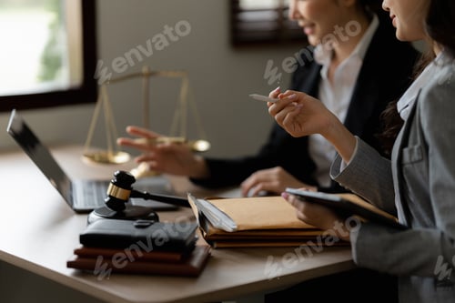 Preview: Business woman and lawyers discussing contract papers with brass scale on wooden desk in office. Law