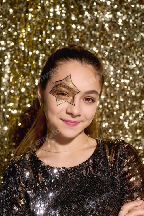 Preview: Cute girl with star face art sparkles in golden sequins for Halloween celebration
