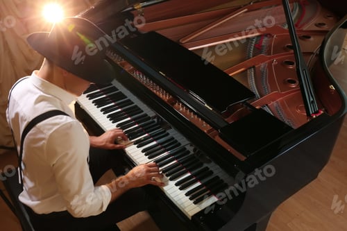 Preview: Man playing piano indoors, above view. Talented musician
