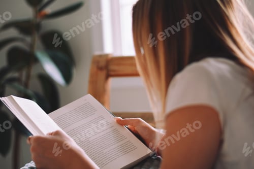 Vorschau: Junges Mädchen liegt auf dem Bett und liest ein Buch