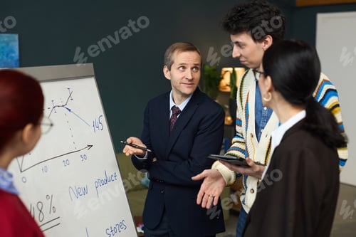 Preview: Middle Aged Man Explaining Business Strategy to Diverse Team