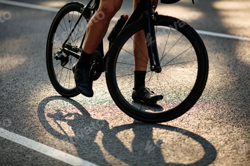 Preview: Close up of male legs riding bike on asphalt road