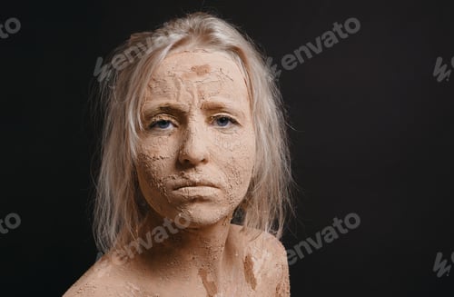 Preview: disheveled woman covered in dry cracked mud