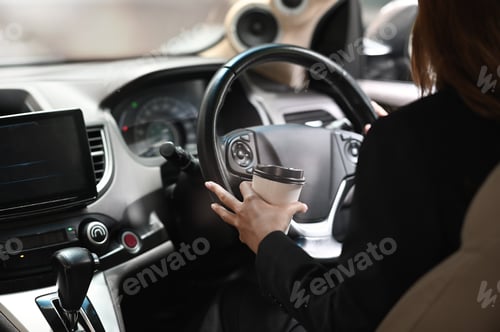 Preview: Business woman driver car and holding coffee cup with closeup shot.