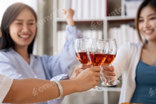 Preview: Group of Asian friends gather to celebrate Christmas with champagne and eating pizza at home. Joy
