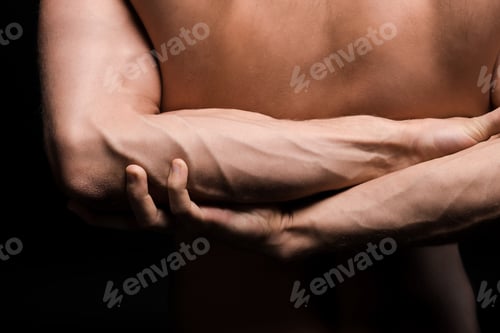 Preview: cropped view of muscular man with hands behind the back, isolated on black