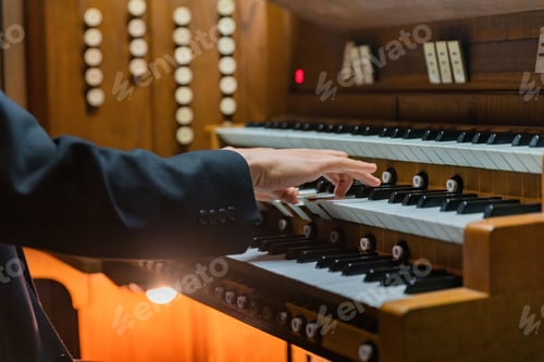 Preview: Closeup shot of a man playing an organ.