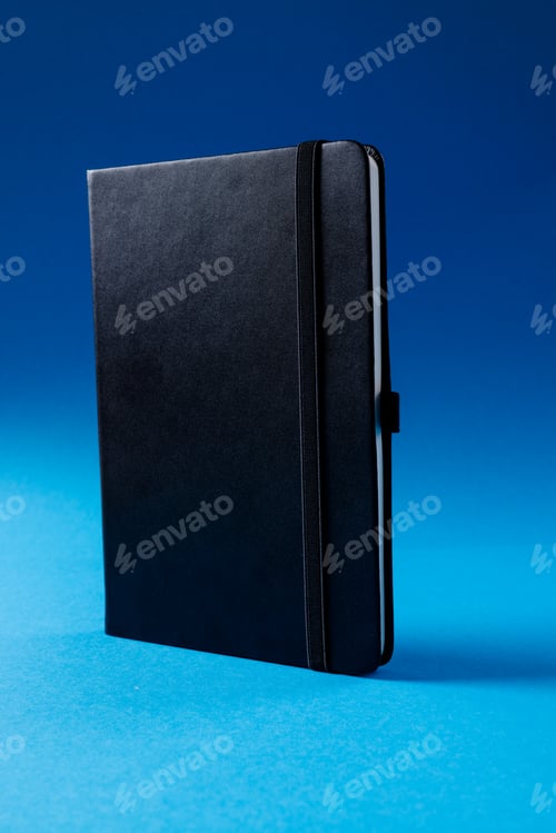 Preview: Close up of black notebook with copy space on blue background