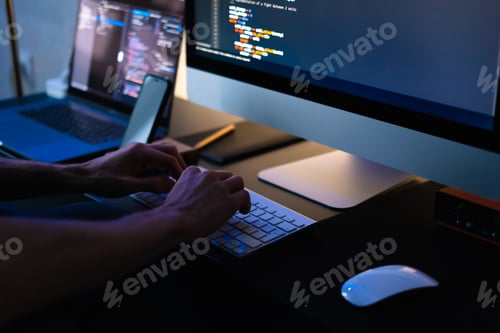 Preview: Mobile developer writes program code on a computer, programmer work in home office.