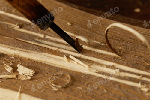 Preview: partial view of chisel sticking in wooden plank with scobs