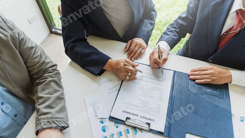 Preview: Business people signing a contract to buy or sell real estate.