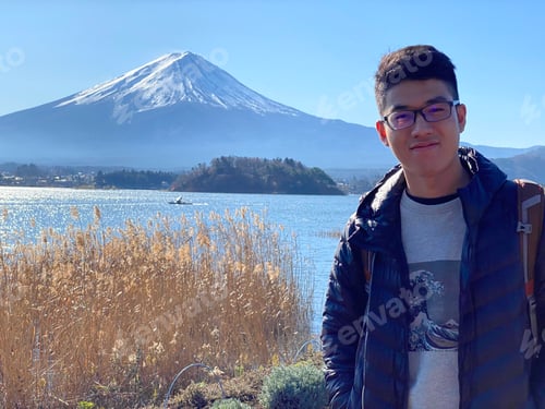 Preview: Asian youth posing for photo with Mount Fuji at the background