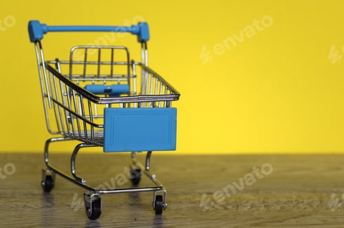 Preview: Mini shopping trolley on yellow background with copy space