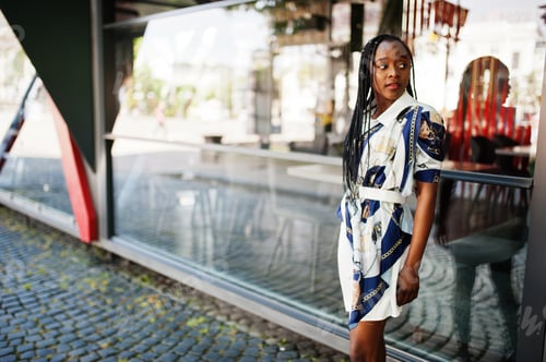 Preview: Portrait of a beautiful natural young African woman with afro hair in dress.