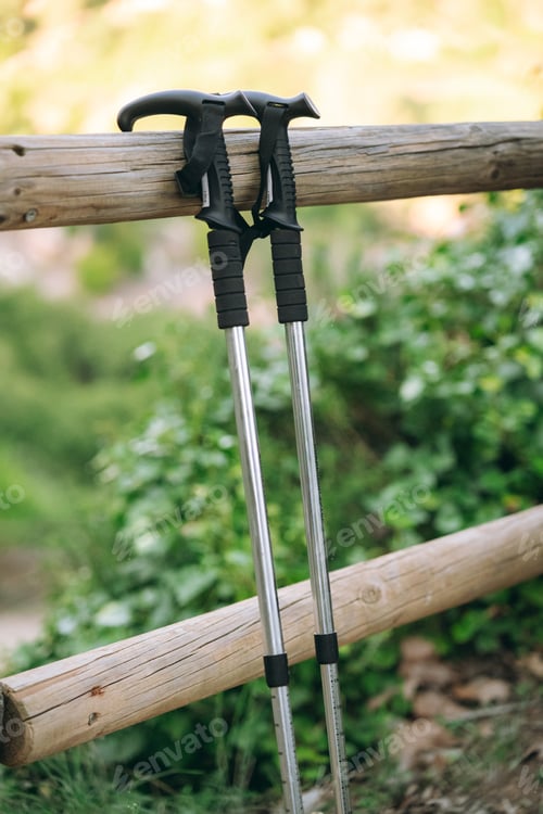 Preview: Trekking poles resting on wooden fence rail