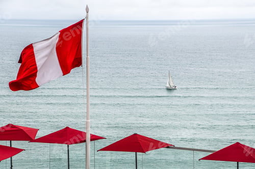 Preview: Beautiful view of the flag of Peru with a sailing boat on the sea in the background