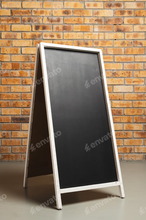 Preview: Black sign in white frame and copy space on brick wall background