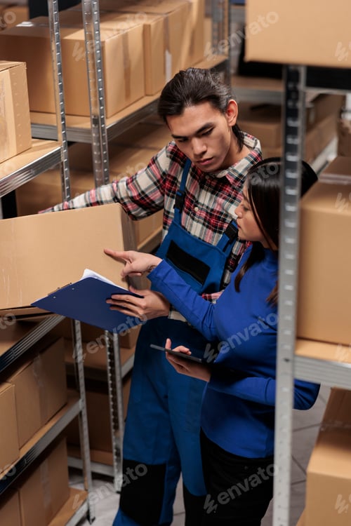 Preview: Warehouse managers taking parcel and checking code on tablet