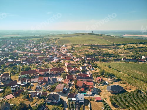 Preview: Aerial view of countryside with town and fields against blue sky, Czech Republic
