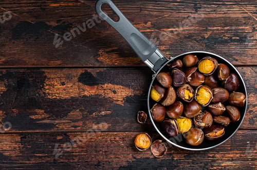 Preview: Roasted chestnuts nuts in a pan. Wooden background. Top view. Copy space