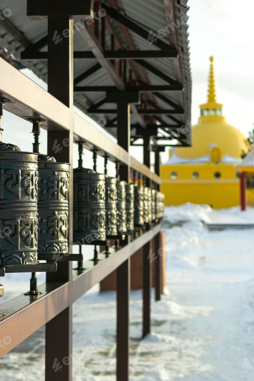 Preview: Traditional spinning prayer wheels with tibetan holy sacred shrine mantras at snowy temple complex