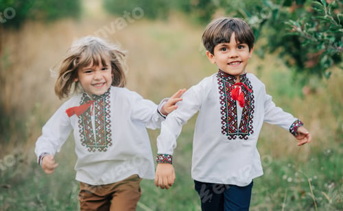 Preview: Little happy boys friends cheerfully running together along path in apple garden