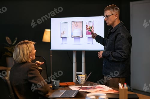 Preview: Young Caucasian Man Presenting Digital Marketing Strategy to Middle Aged Woman