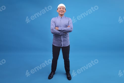 Preview: Full Body Of Young Asian Muslim Man Smiling And Standing Confidently Over Blue Background