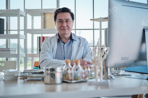 Preview: Portrait of professional senior Asian doctor, happy working in hospital office.