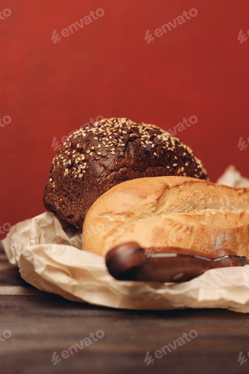 Preview: baking flour products loaf of bread on paper packaging sharp knife and wooden table