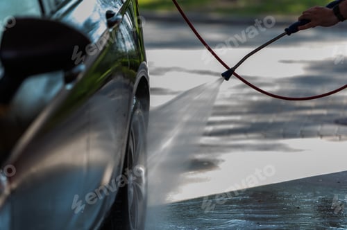 Preview: Car washing. Man cleaning automobile using high pressure jet water.