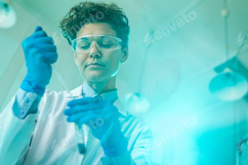 Preview: Young female scientist or researcher dropping chemical substance into flask