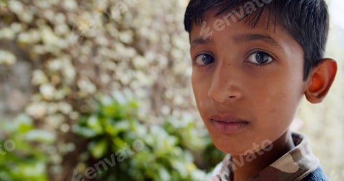 Preview: Shallow focus of a young Indian boy with a serious expression