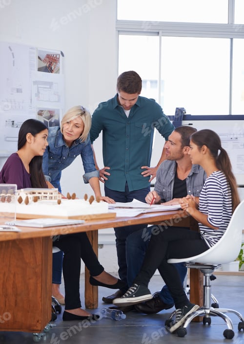 Preview: Cropped shot of a group of architects discussing a scale model