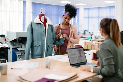 Preview: Female clothing designers cooperating while working in fashion design studio.