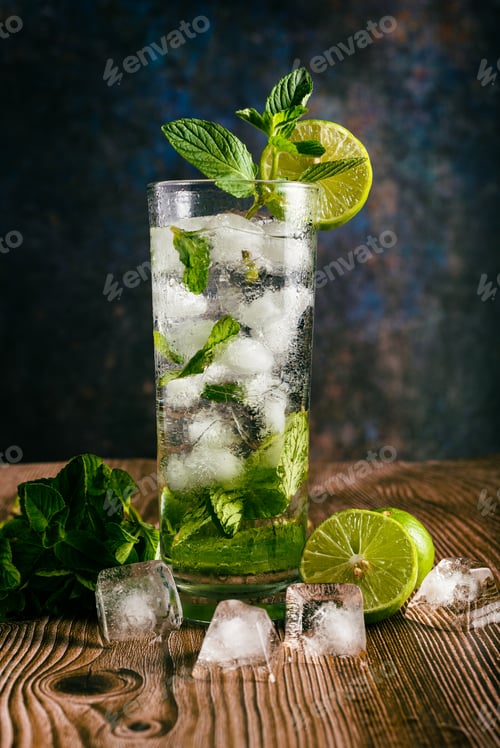 Vorschau: Mojito, mit Zitrone und Pfefferminze dekorierter Cocktail auf einem Holztisch. Kein Strohhalm.