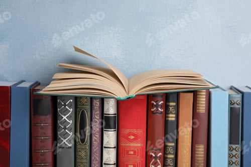 Preview: Open old book on others near blue wall