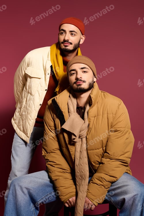 Preview: Stylish twin brothers showcasing trendy fashion poses against a vibrant backdrop