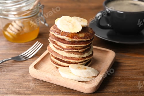 Preview: Plate of banana pancakes served on wooden table, closeup