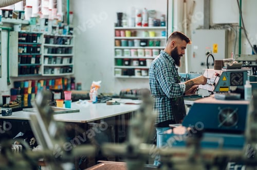 Preview: Male worker using printing machine in a workshop