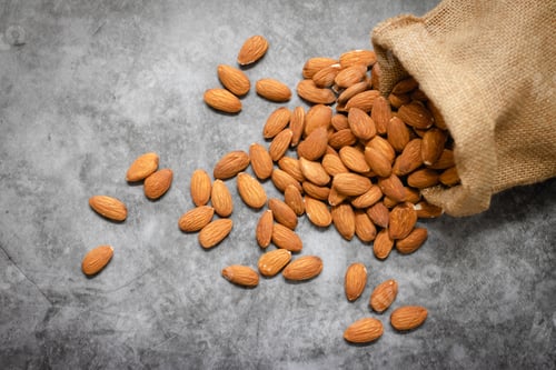 Preview: Almonds in bag from sacking on dark background