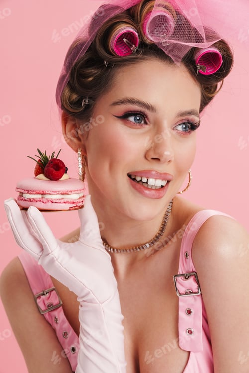 Preview: Smiling woman wearing gloves eating cake while sitting at table
