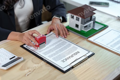 Preview: Real estate agent stamping an insurance policy document for a new house, providing essential safety