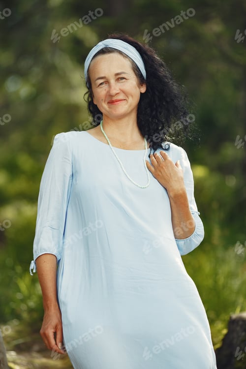 Preview: Stylish adult woman spending time in a summer forest