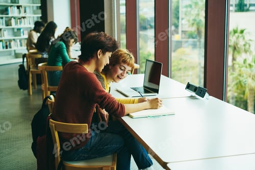 Preview: Young multiethnic group of students studying inside university library - Focus on asian guy face