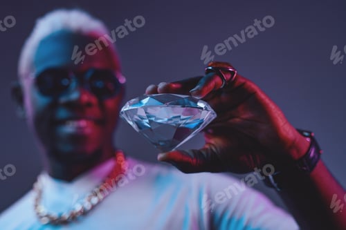 Preview: Joyful african man holding diamond against dark background