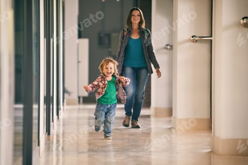 Preview: Little boy running in the shopping center with his mom on background.