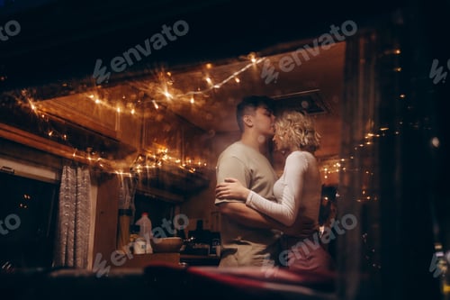Preview: couple in love having fun together in Christmas decorated bed in evening, young man and woman newlyw