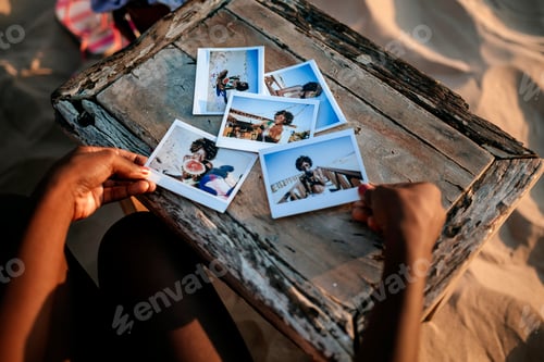 Preview: Tourist looking at instant photos on beach table